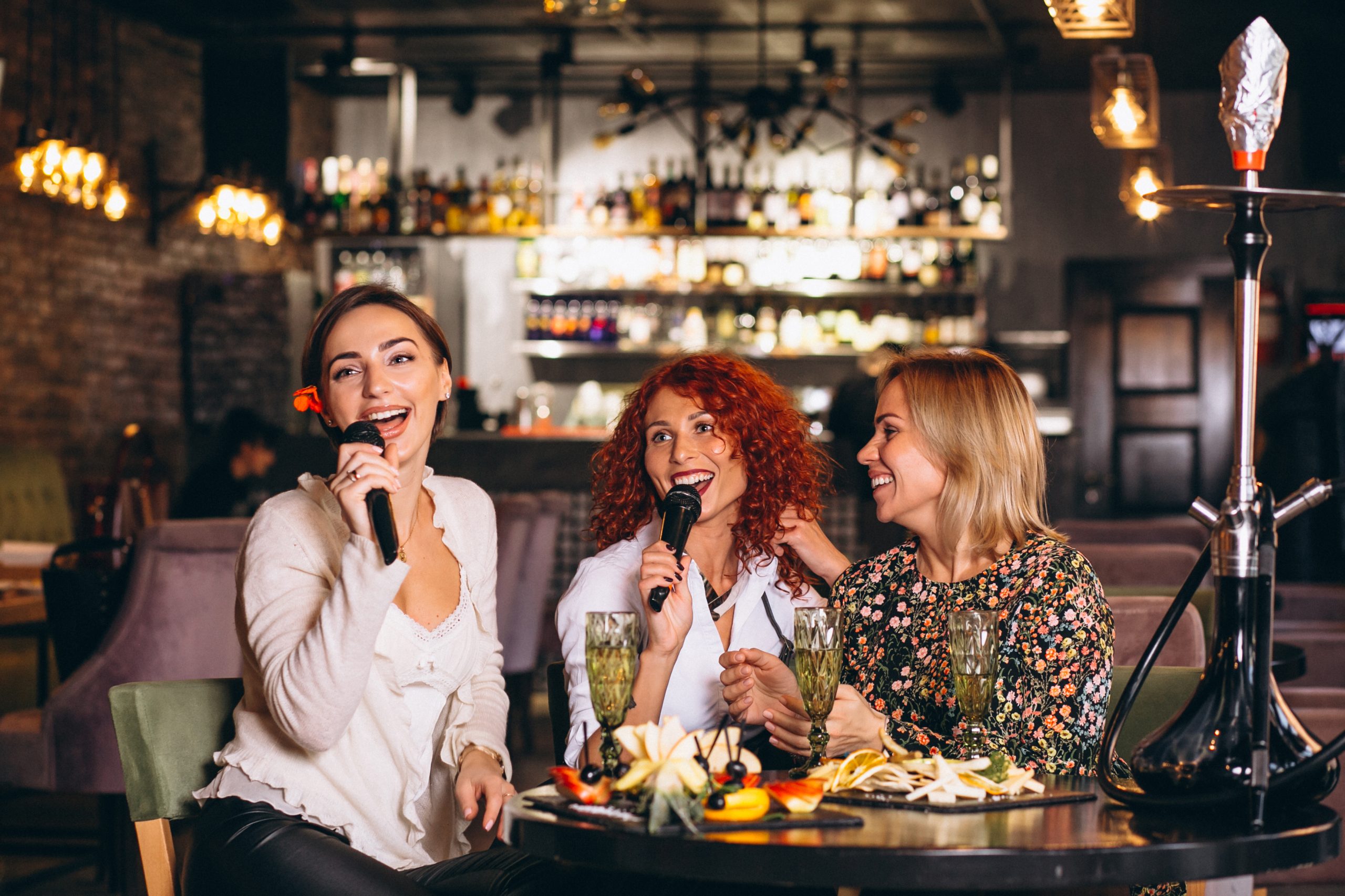 Young women in a bar singing karaoke